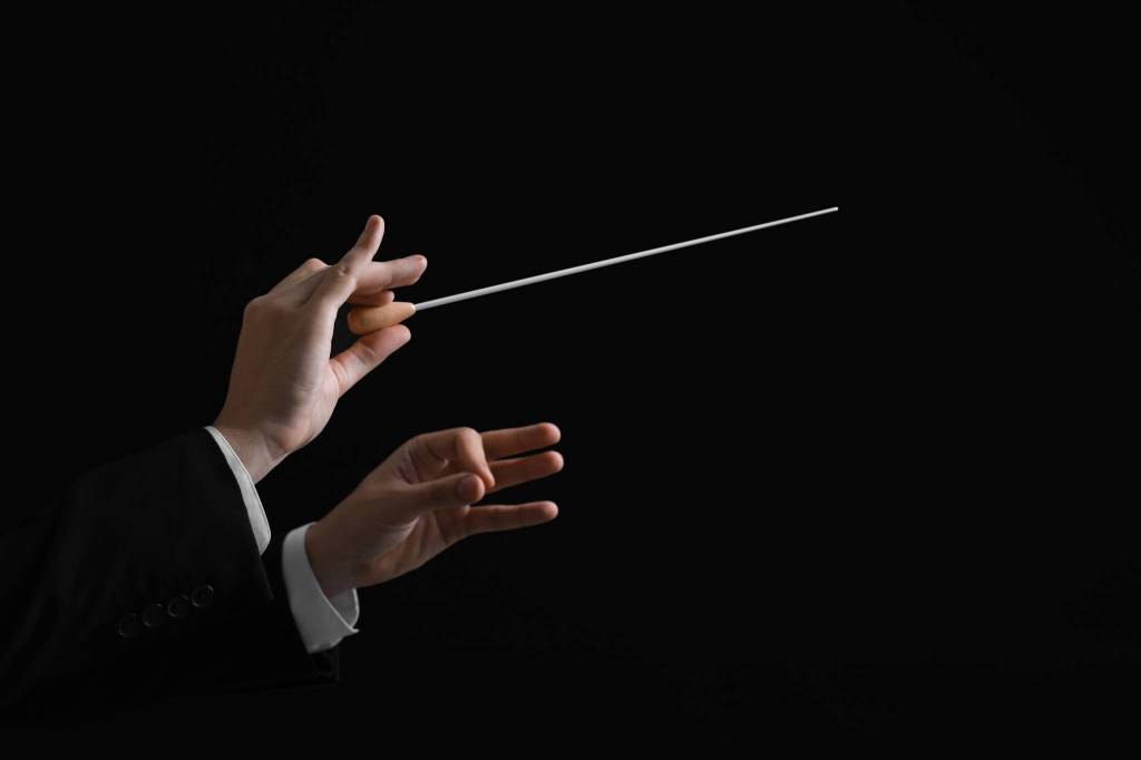 Professional conductor with baton on black background, closeup. Space for text